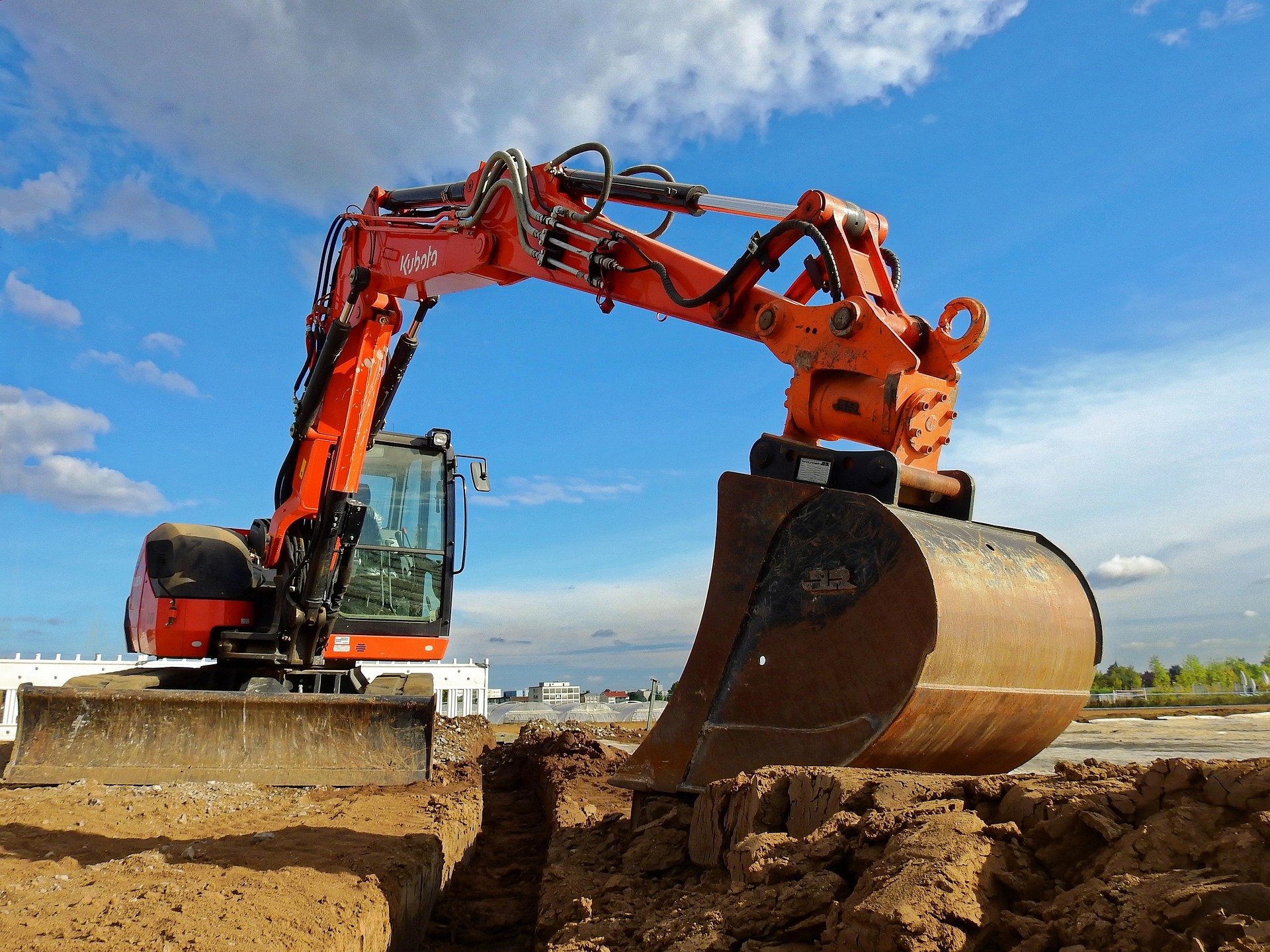 Excavator digging a trench on a Springfield, MO job site